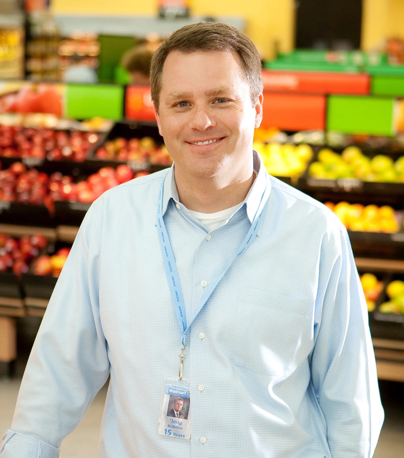Doug McMillon, CEO of Walmart, standing inside a Walmart store smiling.
