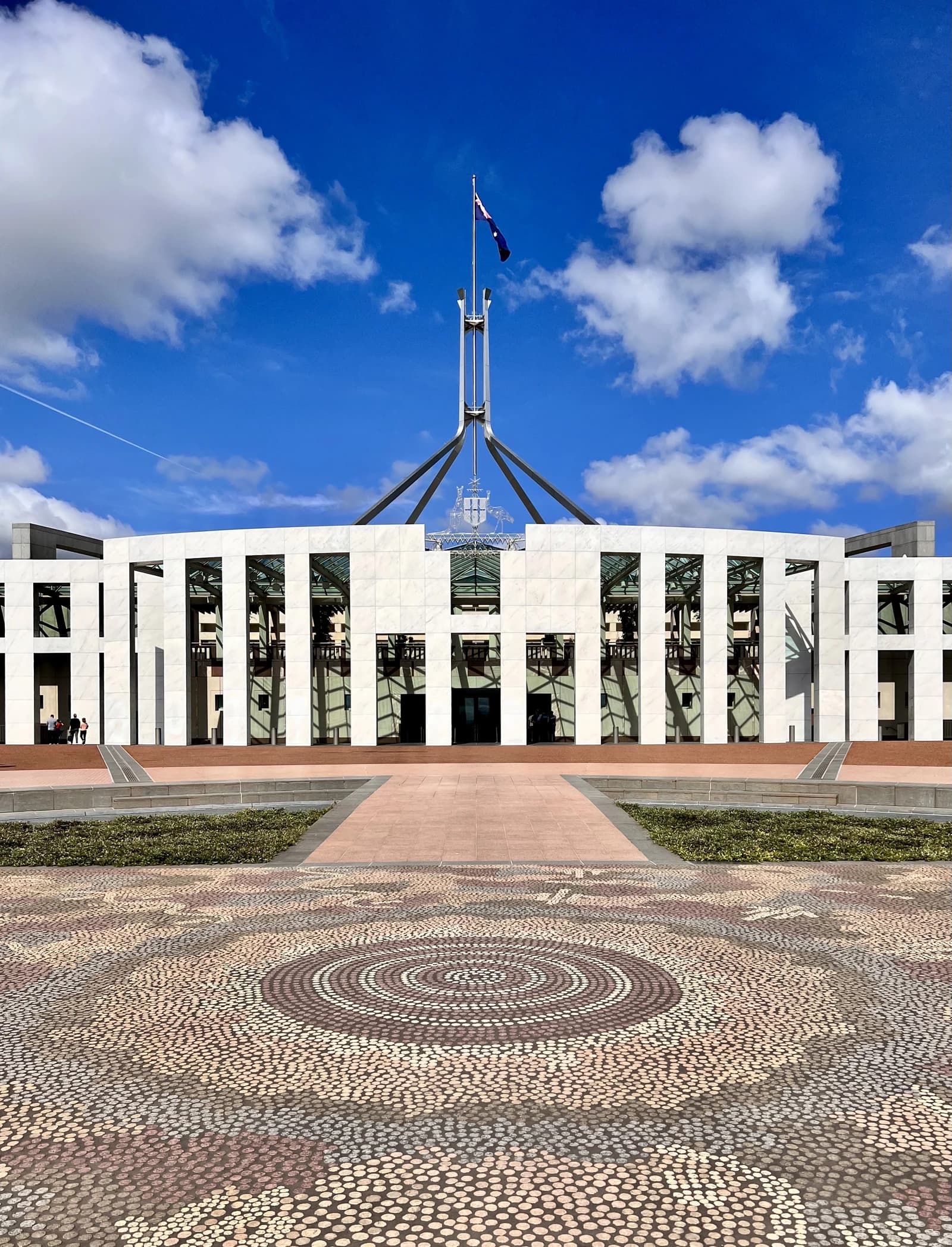Exterior view of Parliament House, Canberra, with flag flying on top.