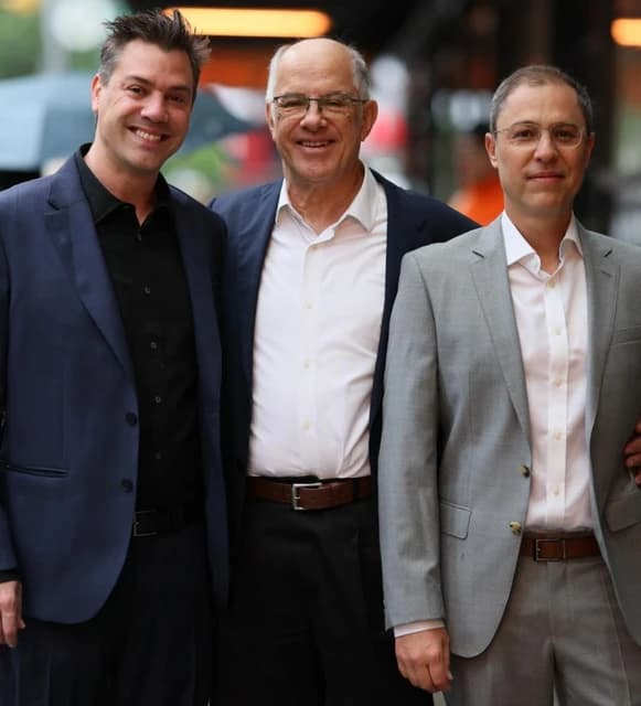 Yoni David and Ronen Assia, founders of eToro, with another man, smiling.