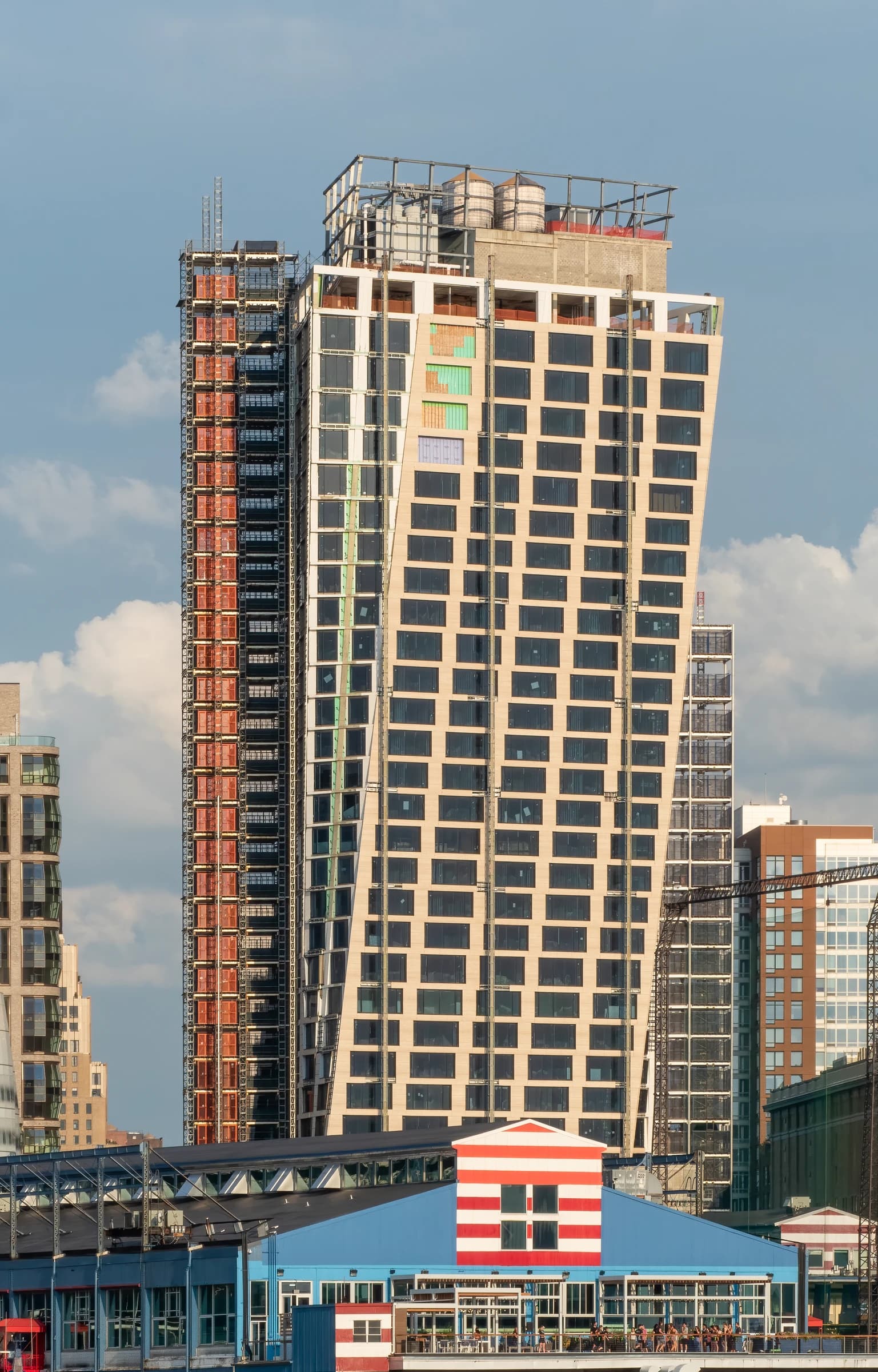 The XI western tower under construction with visible scaffolding and unfinished facade.