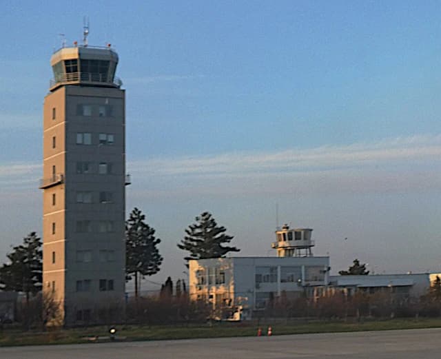 Sibiu International Airport features two control towers under a clear blue sky.