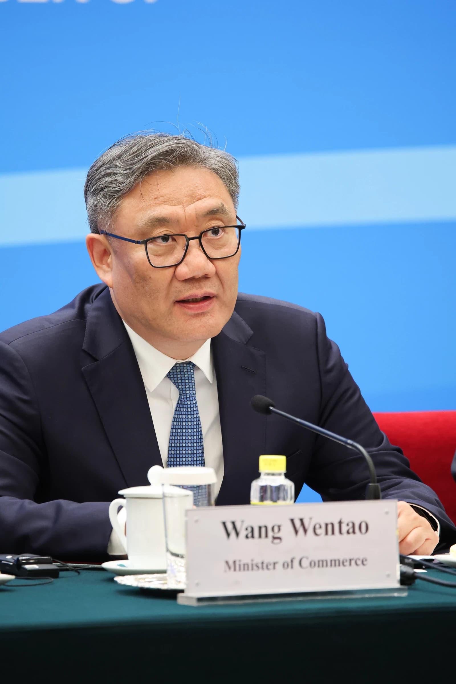 Wang Wentao, China's Minister of Commerce, speaks from a table at a press conference.