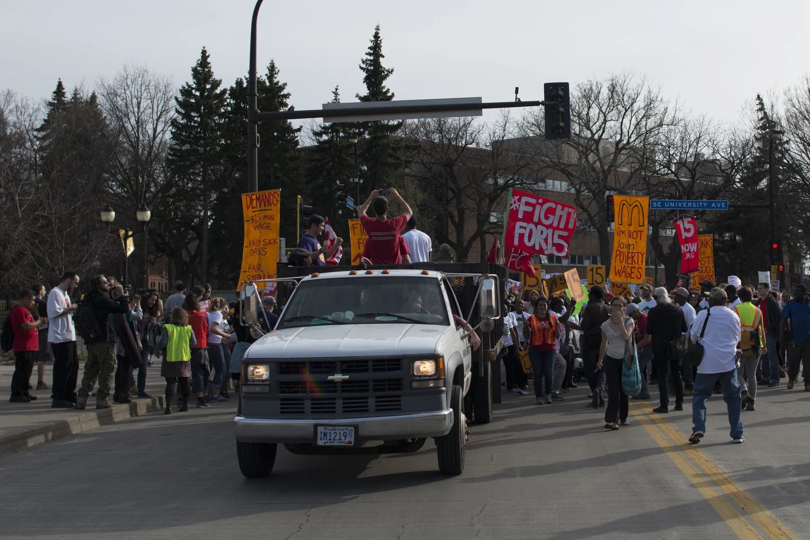 People marching in a street carrying signs during a protest.