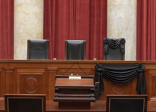 Associate Justice Ruth Bader Ginsburg's chair and the bench in front of her seat at the Supreme Court draped in black.