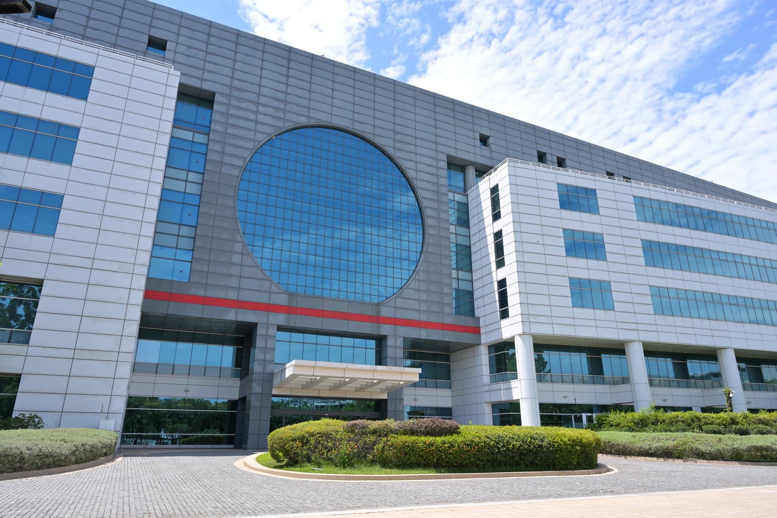 Exterior view of TSMC Fab 6 building with a circular window and modern architecture.