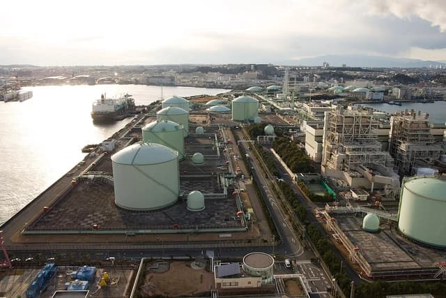 Aerial view of the Negishi LNG Terminal in Japan, with large gas storage tanks.