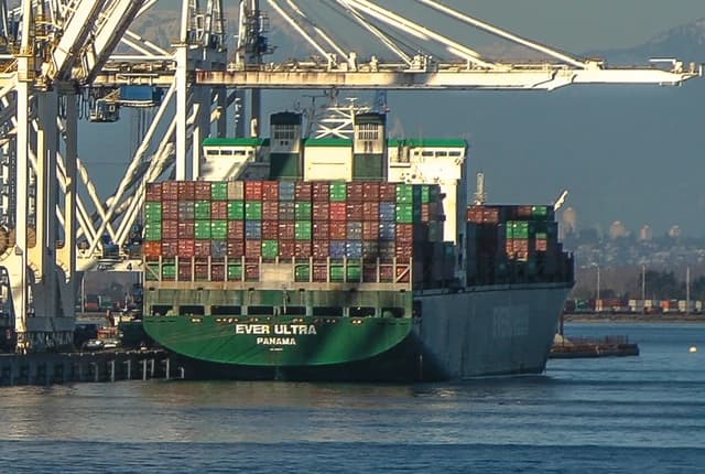 Container ship Ever Ultra docked at Roberts Bank superport, being loaded by cranes.