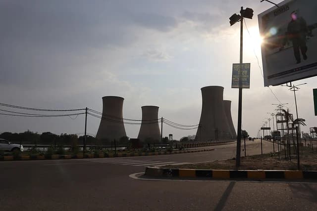 Cooling towers of the Guru Nanak Dev Thermal Plant stand under a cloudy sky.