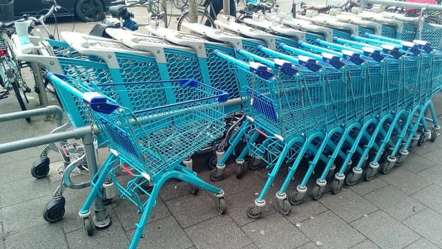 Blue shopping carts lined up outside an Albert Heijn supermarket.