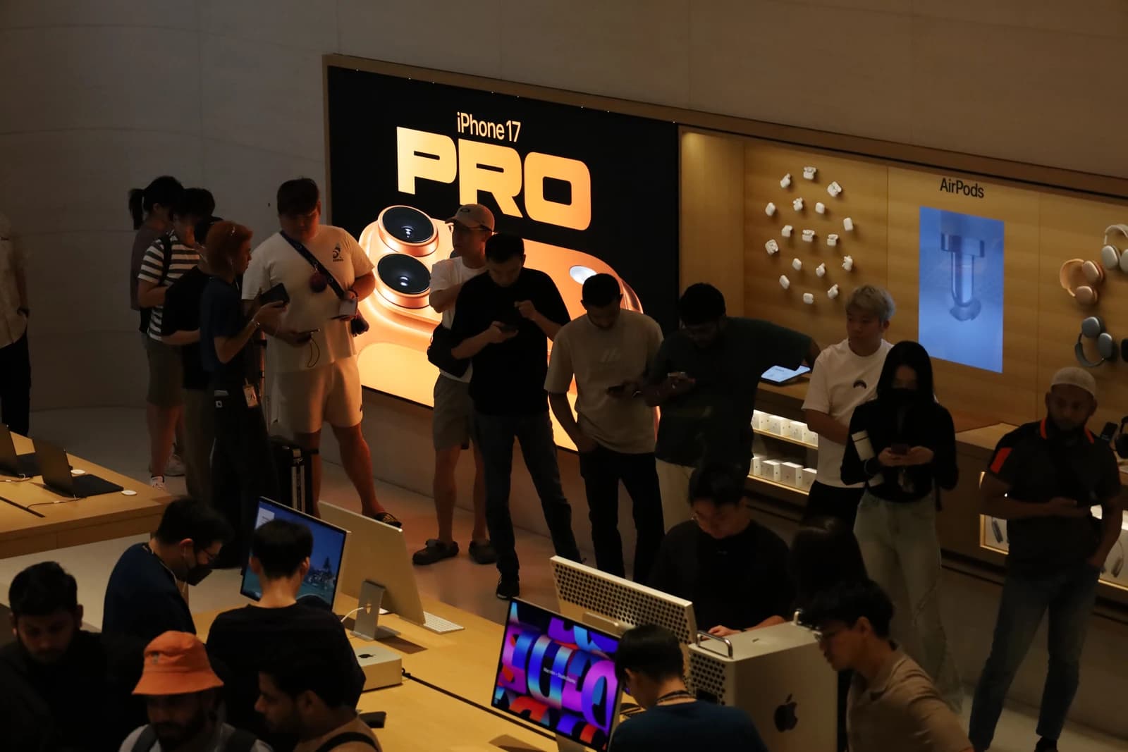 People stand inside an Apple Store looking at phones and computers.