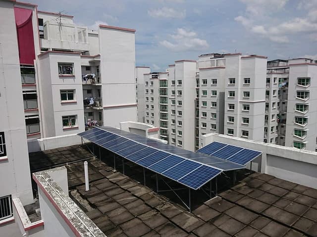 Solar panels on a building rooftop in a residential area.