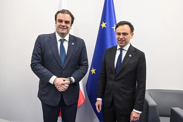 Dimitris Pierrakakis, Greek Minister of State and Digital Governance, standing with a colleague.