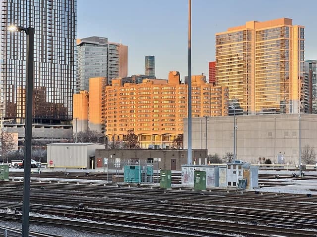 Skyscrapers and residential buildings in Chicago, Illinois with train tracks in the foreground.