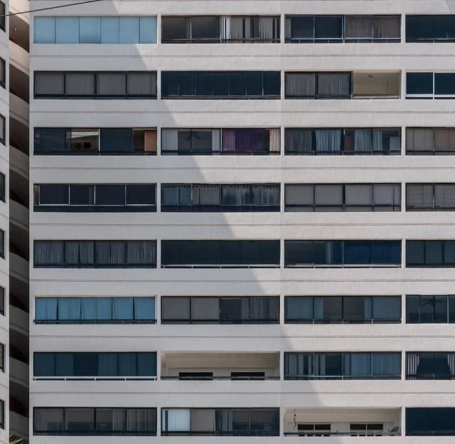 Close-up of a multi-story apartment building facade with many windows and balconies.