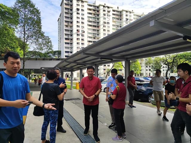 Chee Hong Tat, Singaporean politician, speaking with a person outdoors in an urban setting.