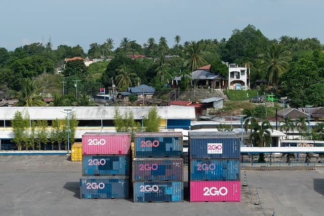 Shipping containers from 2GO logistics stacked at the Port of Nasipit.