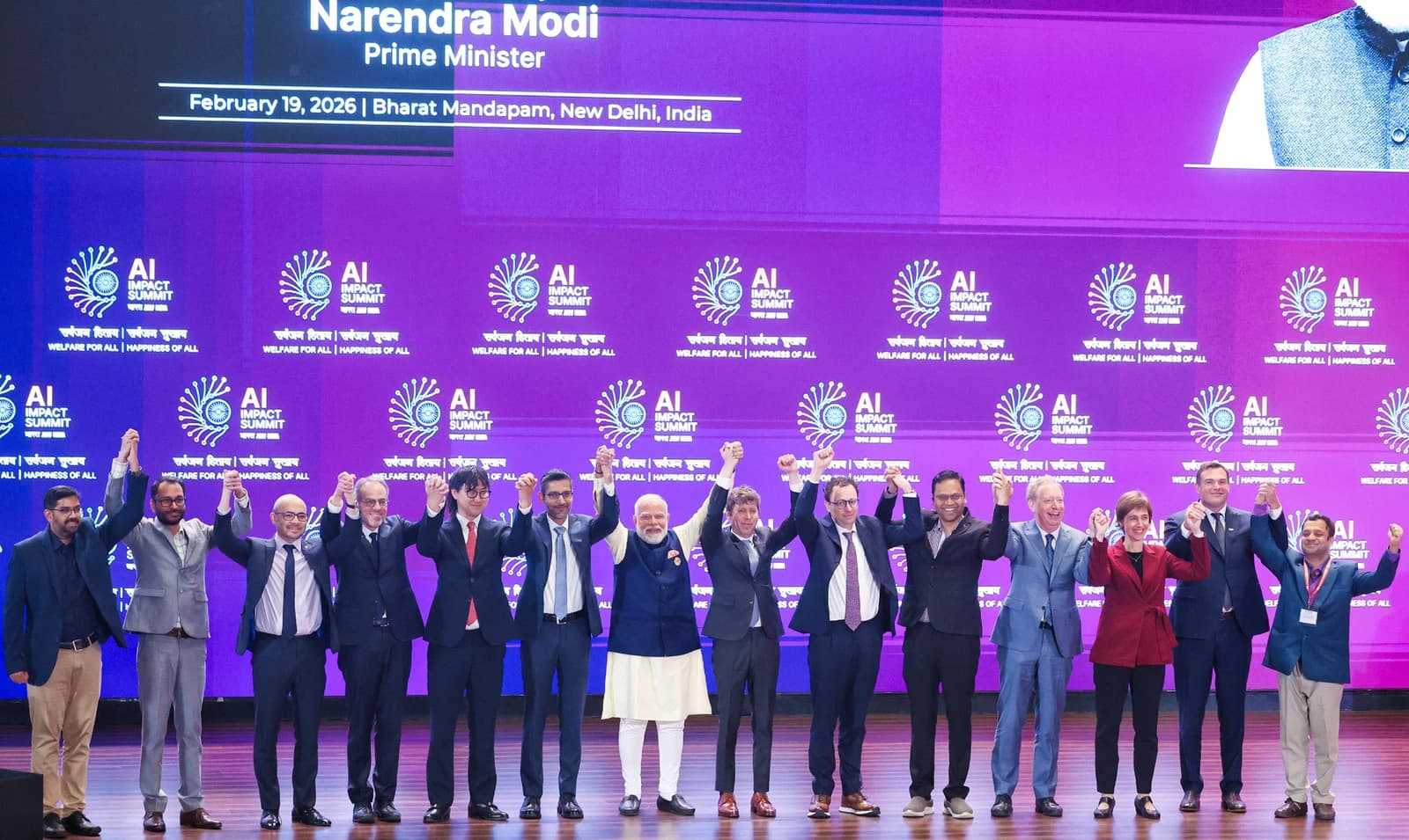 Prime Minister Narendra Modi and global tech leaders pose on stage at an AI summit.