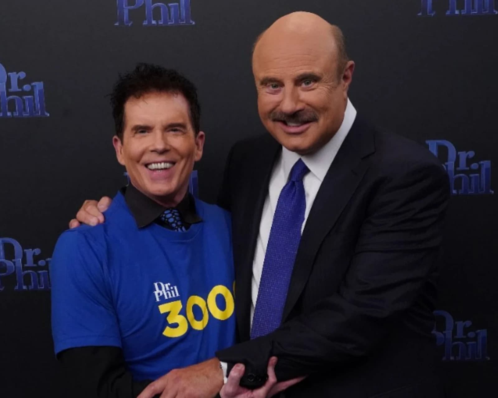 Robert Reames stands next to Dr. Phil McGraw at an event.