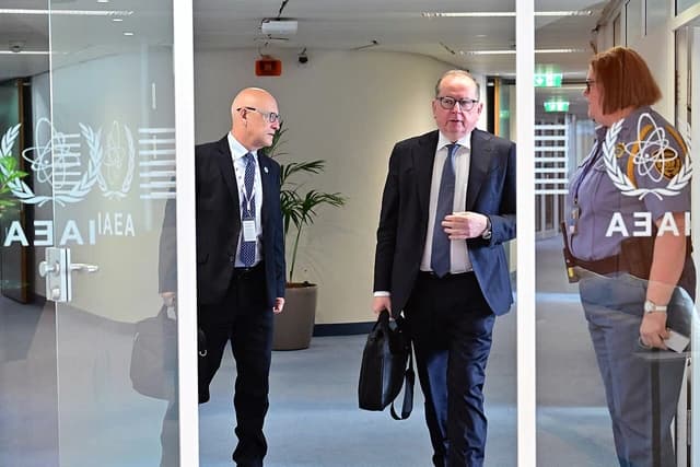 Marek Szczygieł, in a suit, walking at an IAEA meeting in Vienna.