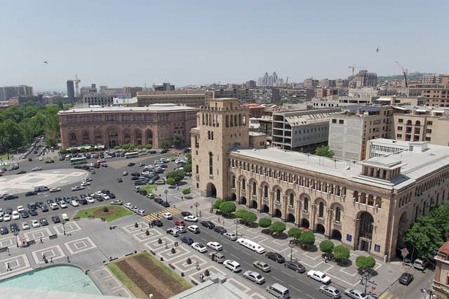 Aerial view of Republic Square in Yerevan, Armenia, showing historical buildings and moving traffic.