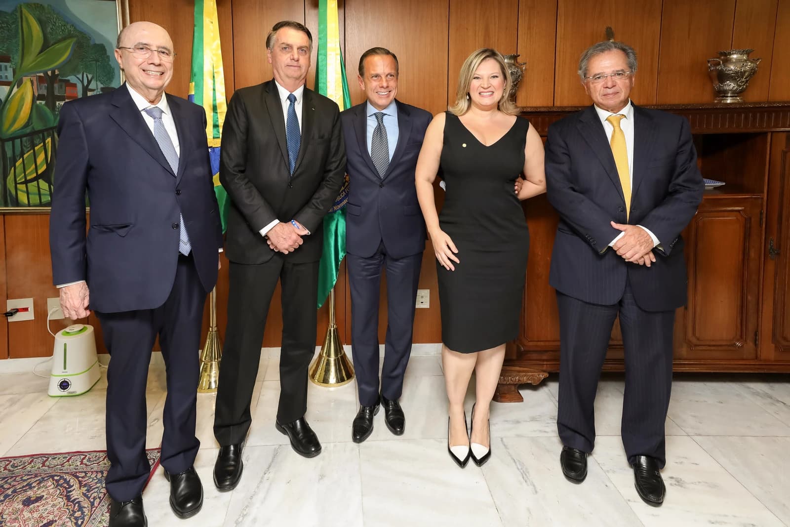 Jair Bolsonaro, then-President of Brazil, stands with four other politicians in a formal setting.