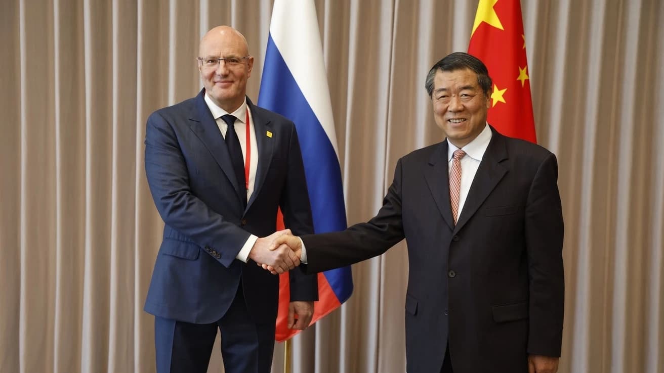 He Lifeng and Dmitry Chernyshenko shake hands during a bilateral meeting.