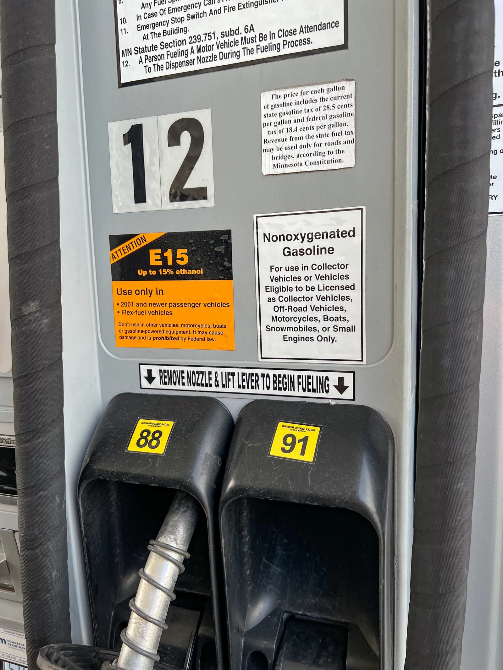 Gas pump showing nozzles for 88 and 91 octane gasoline, with various informational stickers.