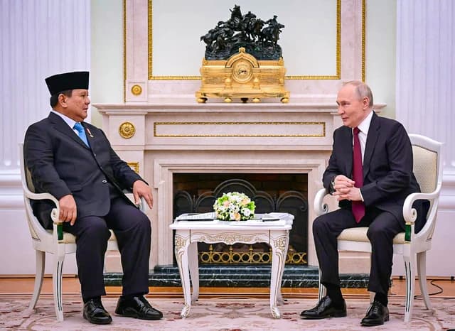 Vladimir Putin, President of Russia, sits opposite Prabowo Subianto in a formal room.