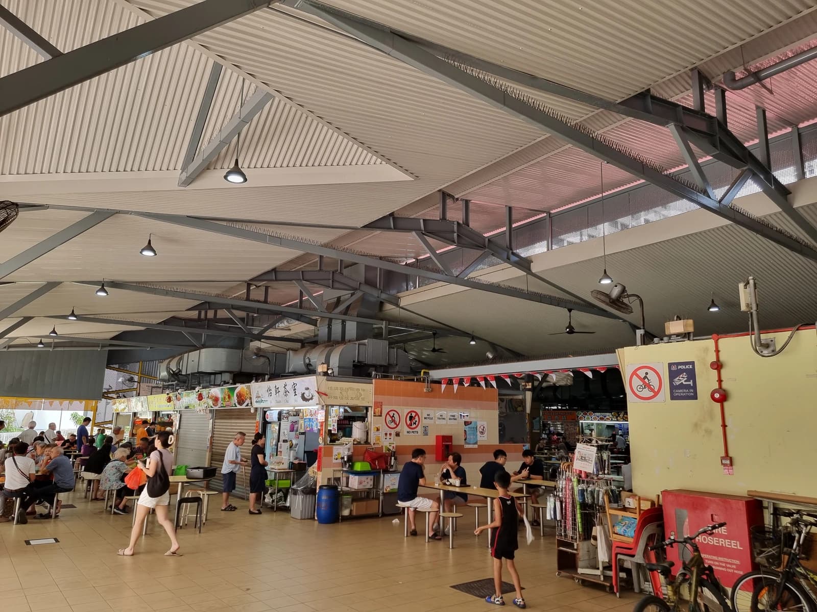 People dining and ordering at food stalls inside Sims Vista Market and Food Centre.