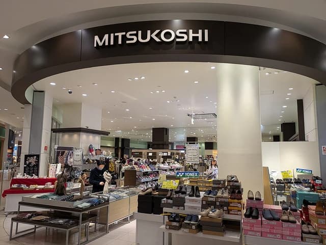 Interior view of a Mitsukoshi department store with clothing and shoe displays.