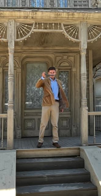 Man holding a knife on the porch of a house at Universal Studios Hollywood.