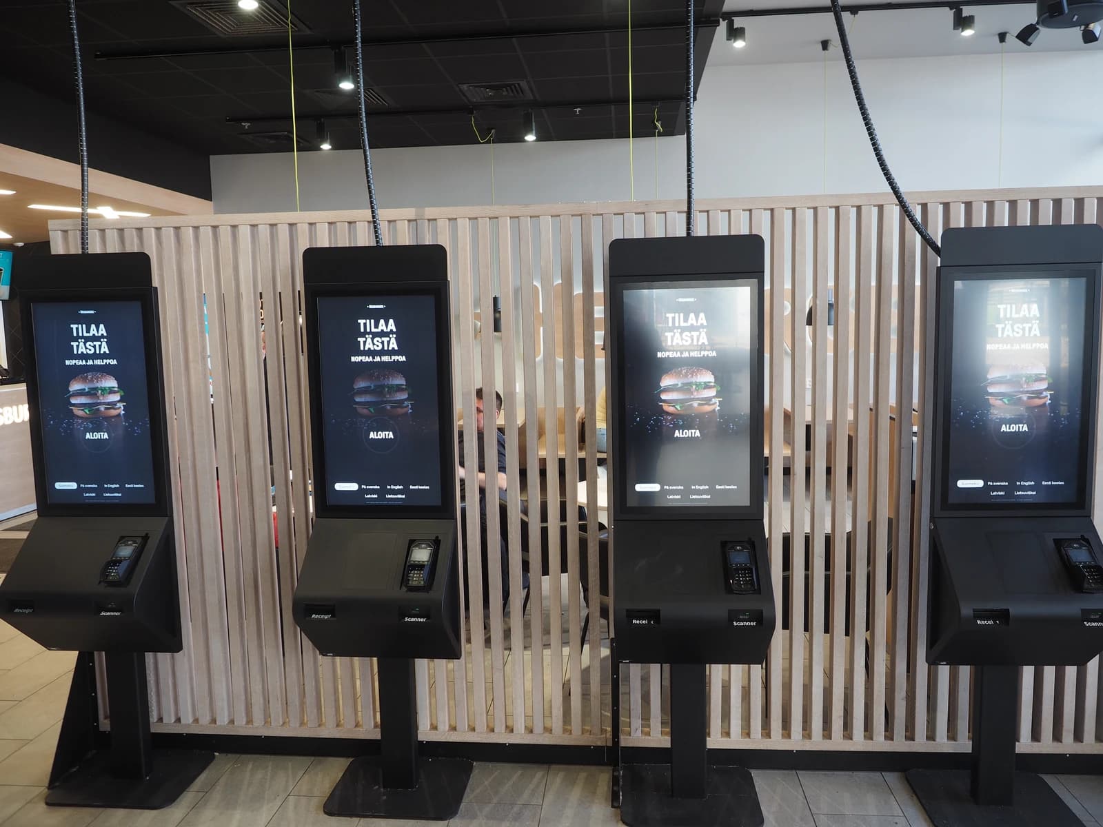 Automated ordering kiosks inside a Hesburger fast food restaurant.