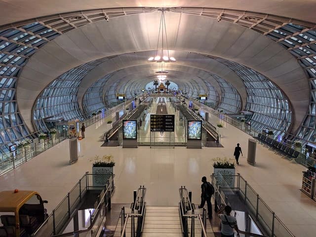 Interior view of Suvarnabhumi Airport terminal with people walking.