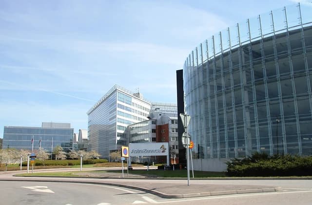 Exterior of AstraZeneca's Mölndal facility, modern glass buildings and surrounding landscape.