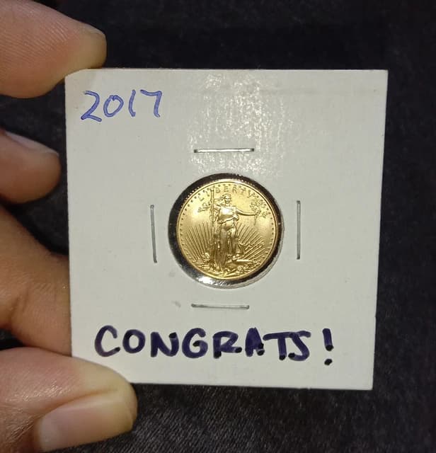 One-tenth ounce American Gold Eagle coin from 2017 held in a white paper holder.