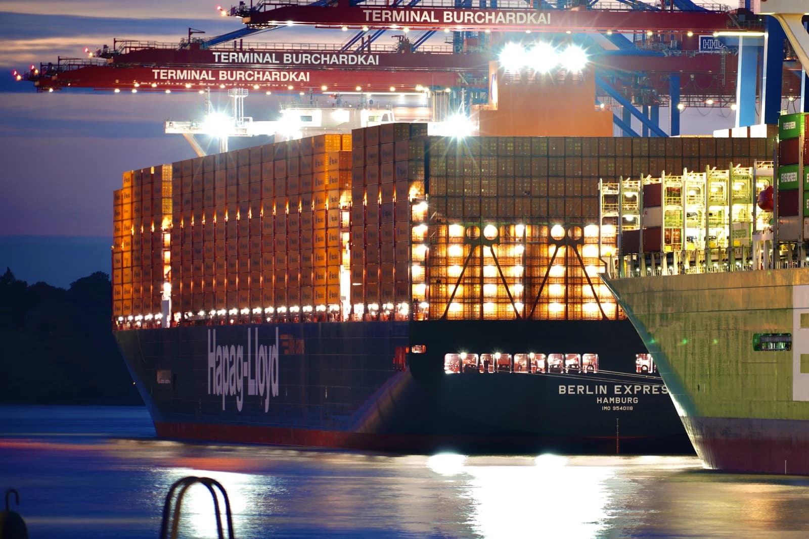 The Hapag-Lloyd container ship Berlin Express docked at a port at night.