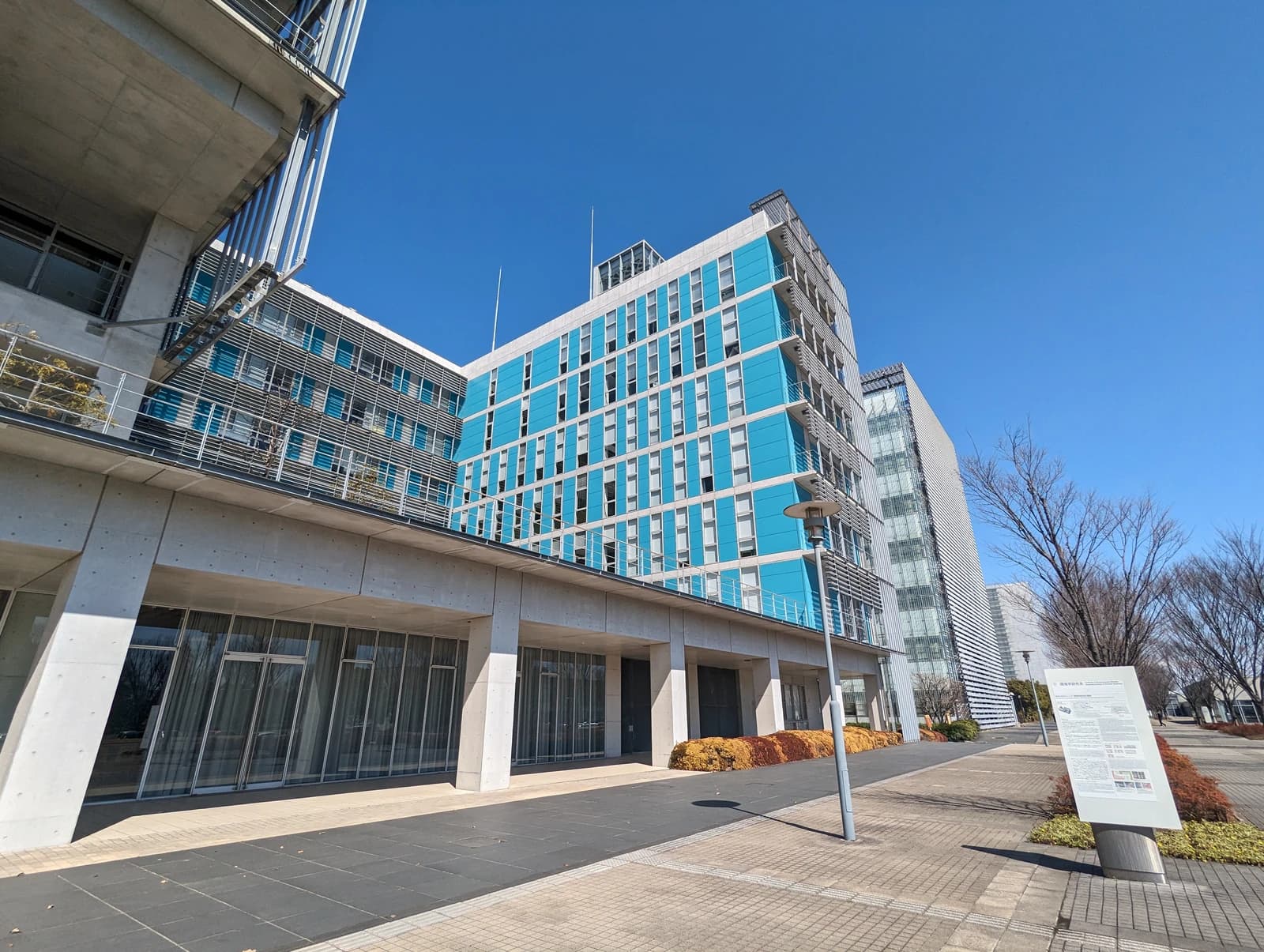 Modern building with blue and gray facades under a clear blue sky.