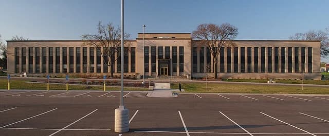 The 3M Administration Building, a large beige stone structure with many windows.
