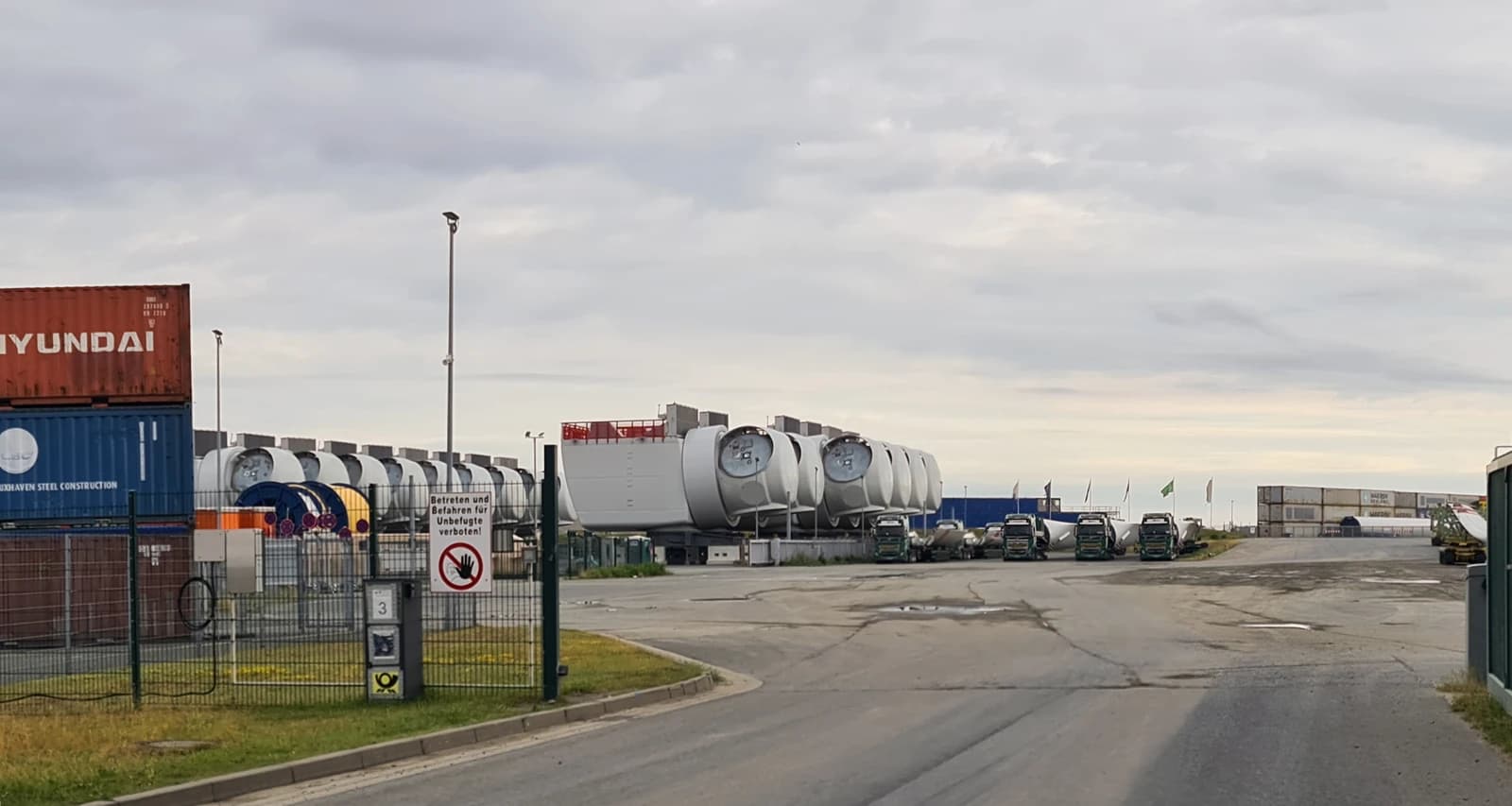 Wind turbine nacelles loaded on trucks at a port or staging area.