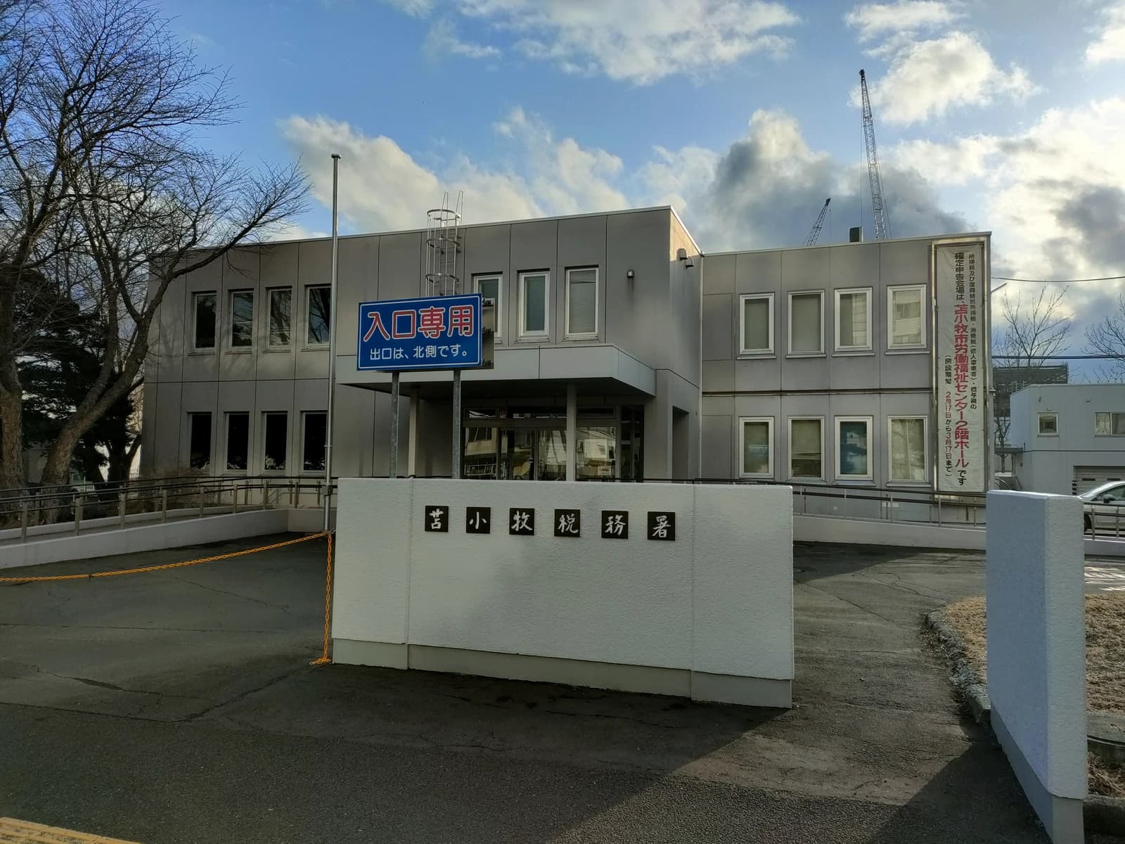 Tomakomai Tax Office building with Japanese signage and surrounding bare trees.