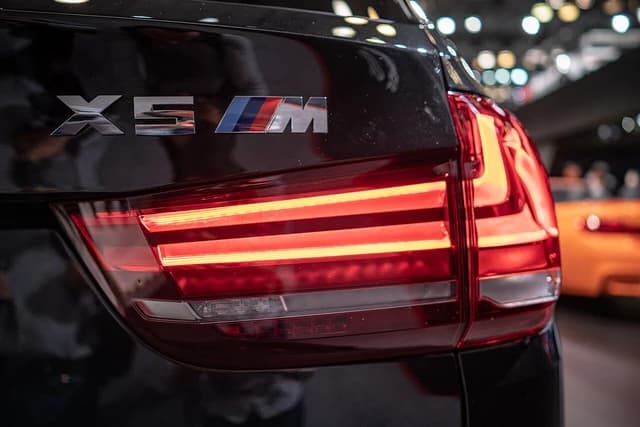 Close-up of the rear taillight and X5 M badging on a dark-colored BMW X5.