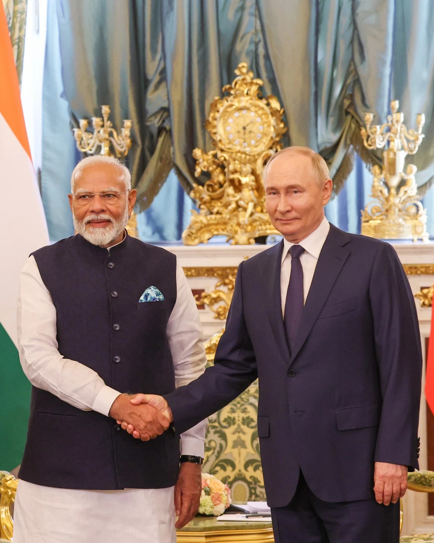 Indian Prime Minister Narendra Modi and Russian President Vladimir Putin shaking hands indoors.