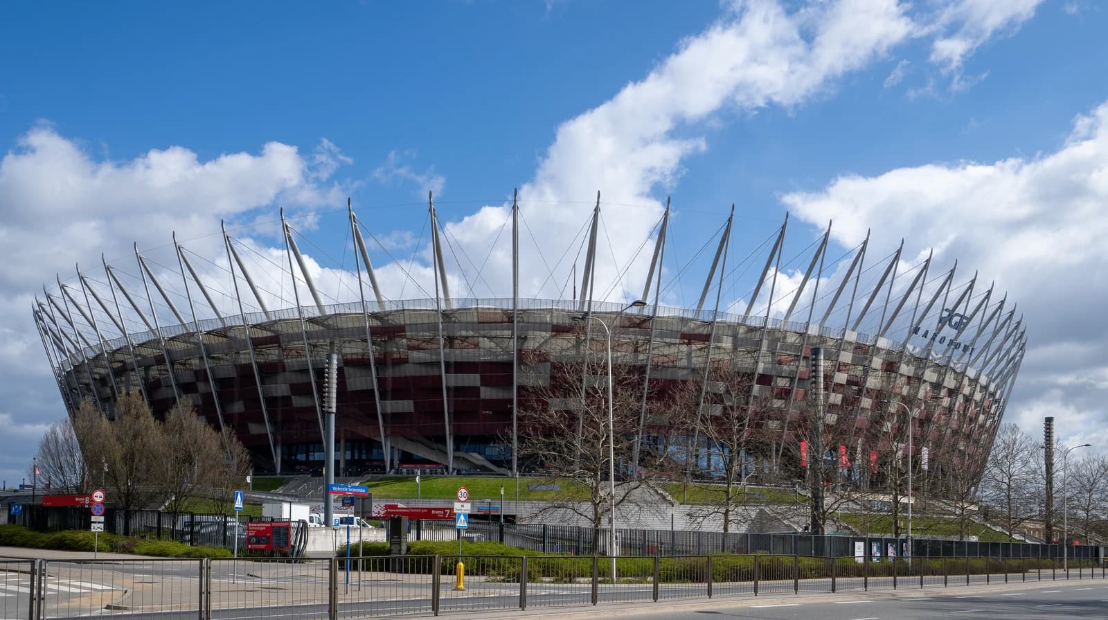 Kazimierz Górski National Stadium in Warsaw, Poland, under a partly cloudy sky.