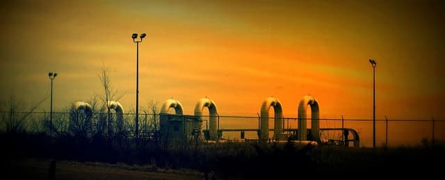 Segments of the TransCanada Keystone oil pipeline against an orange sky.