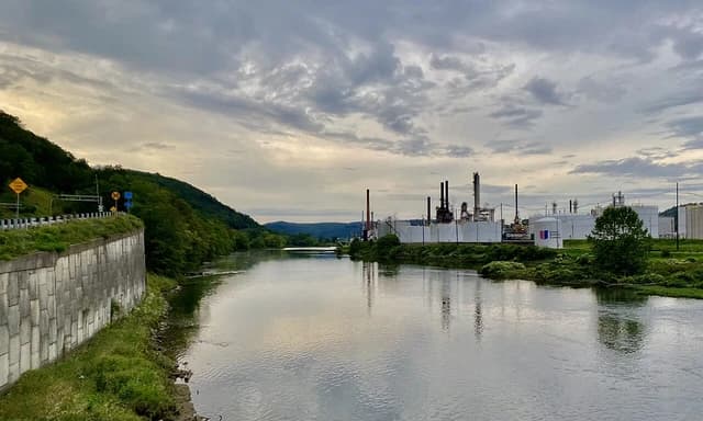 United Oil Refinery facilities with smokestacks and storage tanks along the Allegheny River.