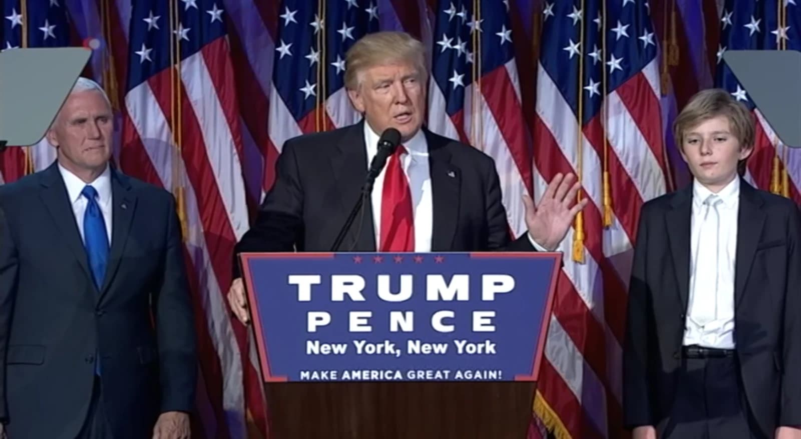 Donald Trump speaking at a podium with American flags in the background.