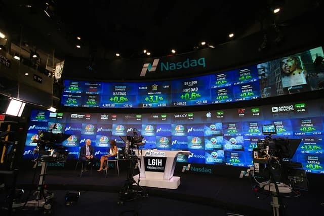 Interior of the Nasdaq MarketSite with large digital screens displaying stock market data.