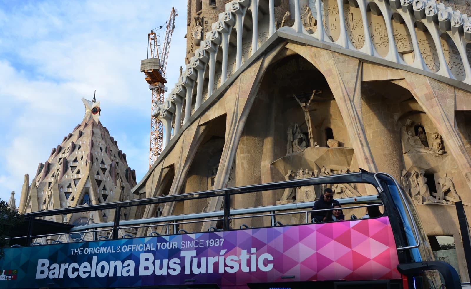 Tourist bus passes in front of the Sagrada Familia basilica in Barcelona, Spain.