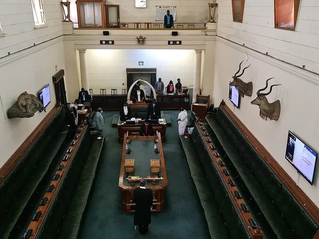 Interior of the House of Assembly of Zimbabwe chamber with members standing and seated.