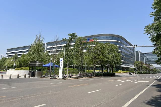 Baidu Technology Park building along a road with trees and a street sign.